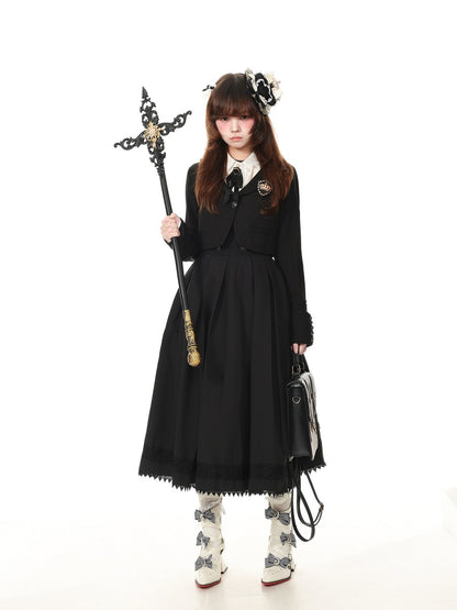 A model wearing a black Victorian-style Lolita dress with a pleated skirt, holding a decorative black and gold staff, and carrying a black handbag against a solid white background.