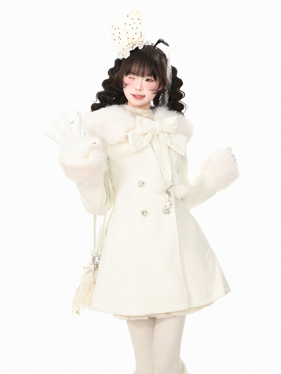 A young girl modeling a cream-colored double-breasted coat with a large faux-fur collar, matching gloves, and a decorative bunny head headband, set against a plain white background.