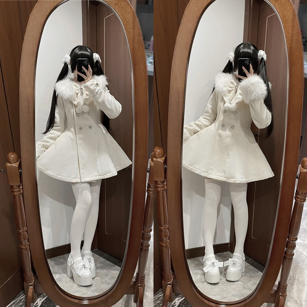 A person taking a mirror selfie wearing a cream-colored double-breasted coat with a fluffy collar, white tights, and white platform shoes, shown in front of a large wooden-framed floor mirror.