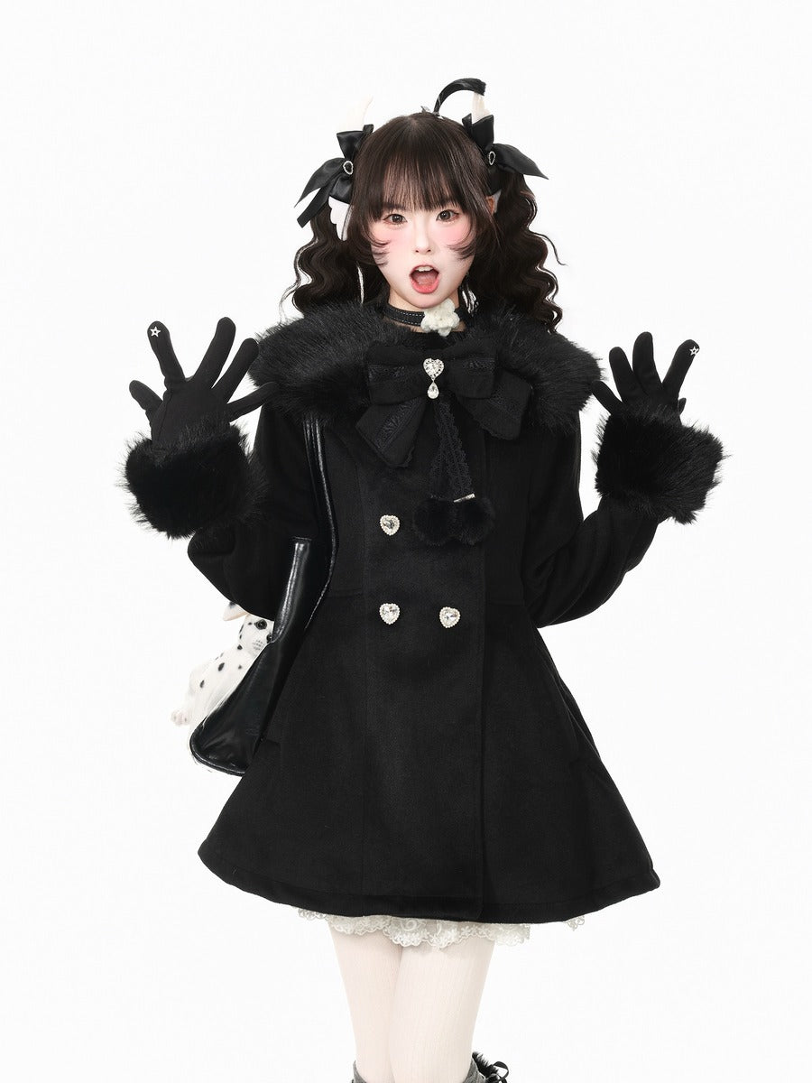 A model posing in a black double-breasted coat with a large bow and faux fur collar, matching black gloves, and black cat-ear hair accessories, set against a plain white background.