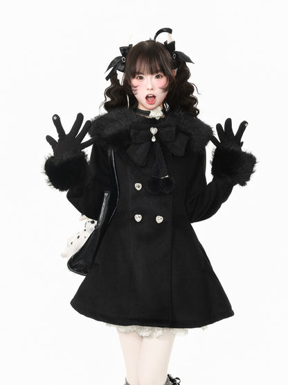 A model posing in a black double-breasted coat with a large bow and faux fur collar, matching black gloves, and black cat-ear hair accessories, set against a plain white background.