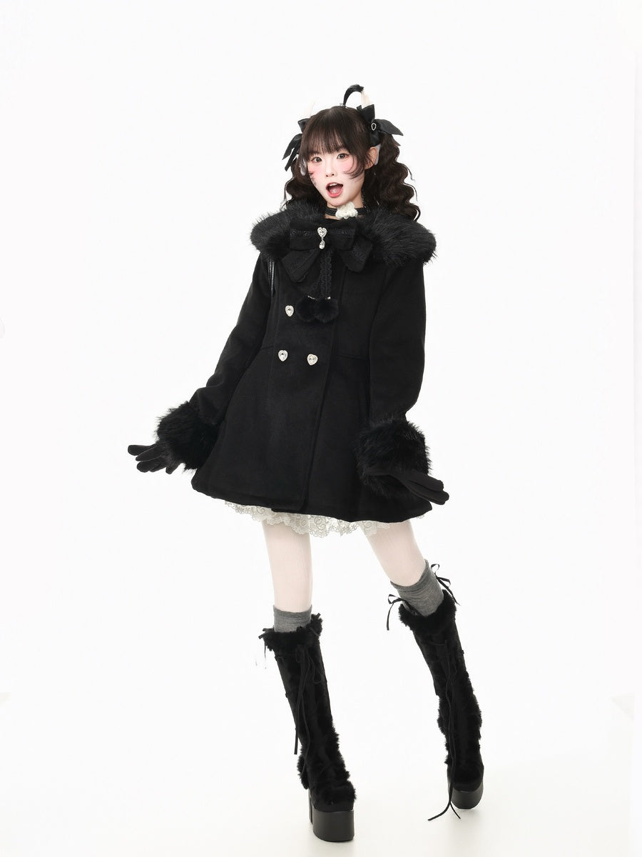 A model wearing a black double-breasted coat with a fluffy collar, black gloves, and tall black platform boots, posing against a solid white background.