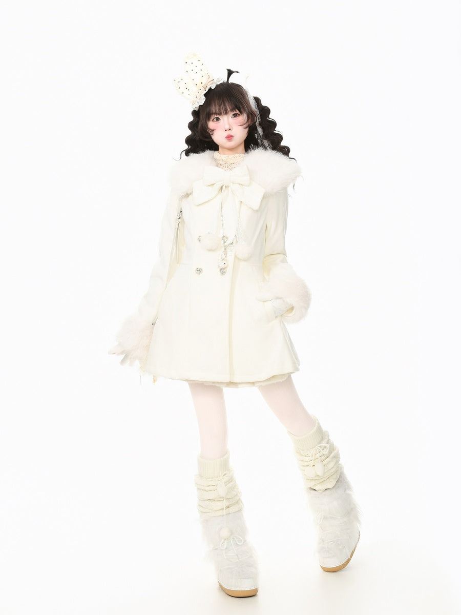 A young girl modeling a cream-colored winter outfit consisting of a short coat with a large bow, fluffy collar, matching mittens, a decorative headpiece, and fluffy lace-up boots, set against a solid white background.