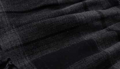 Close-up of a dark charcoal gray and black plaid fabric texture with a woven pattern.