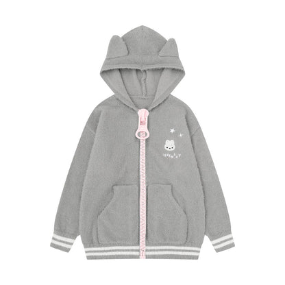 A children's gray zip-up hoodie with a plush texture, featuring cat-ear shaped hood, a pink zipper pull, a small cartoon bunny graphic on the left chest, and striped ribbed cuffs and hem.