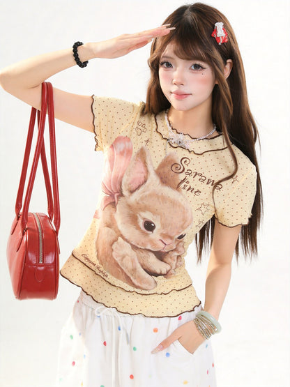 Woman wearing a shirt with a bunny design and holding a red handbag.