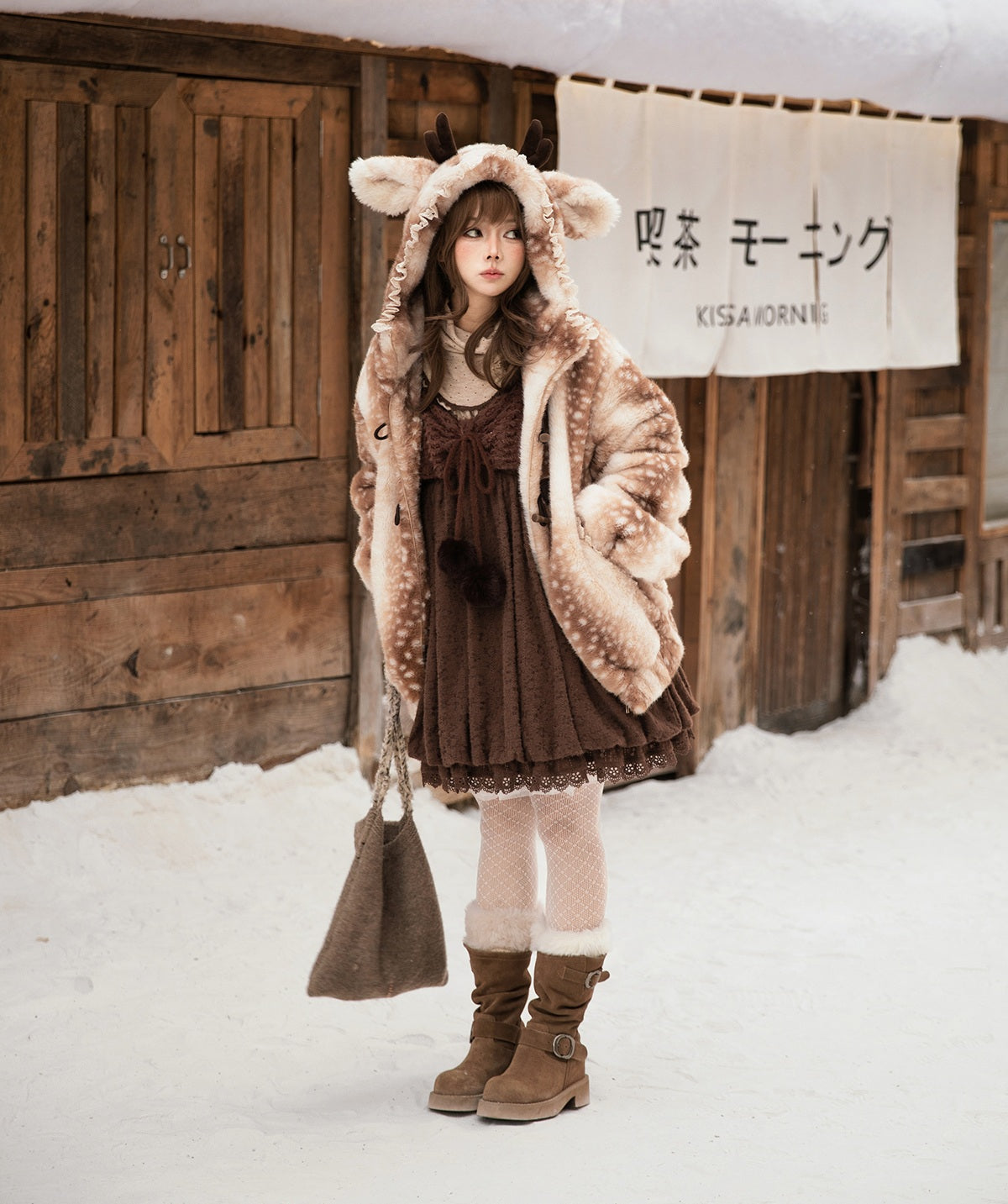 Person wearing a cute lolita style brown deer jacket outfit with a fur-lined hood in a snowy setting.