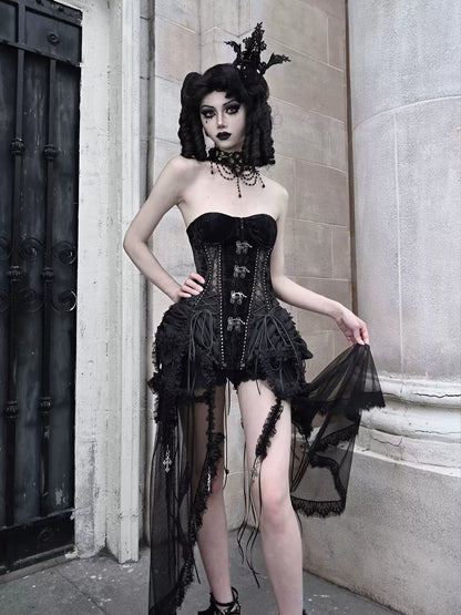 Person wearing a black gothic-style dress with sheer elements in an urban setting.