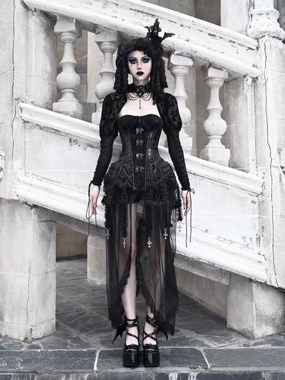 Person wearing a black gothic outfit standing on stone steps.