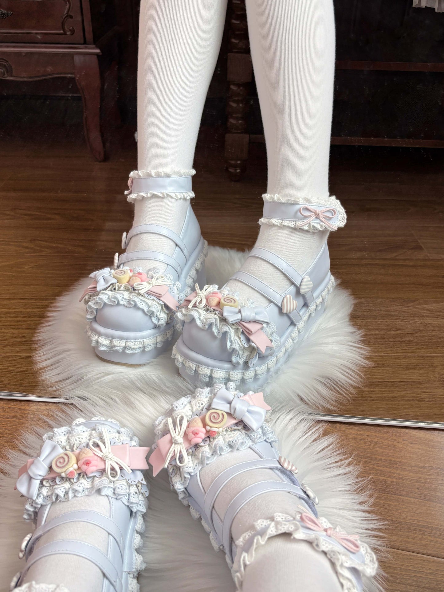 Pastel-colored blue shoes with floral decorations on a wooden floor.