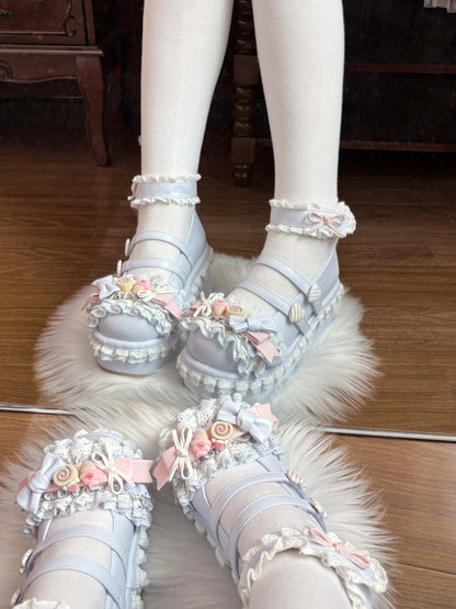 Pastel-colored blue shoes with floral decorations on a wooden floor.