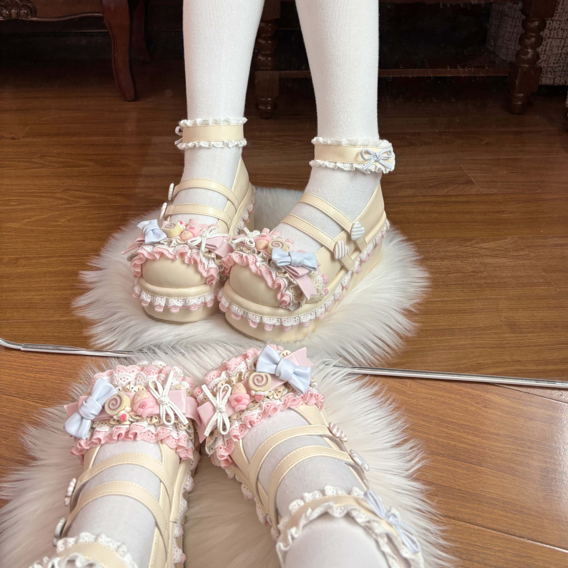Pair of ornate shoes with decorative ribbons on a wooden floor.