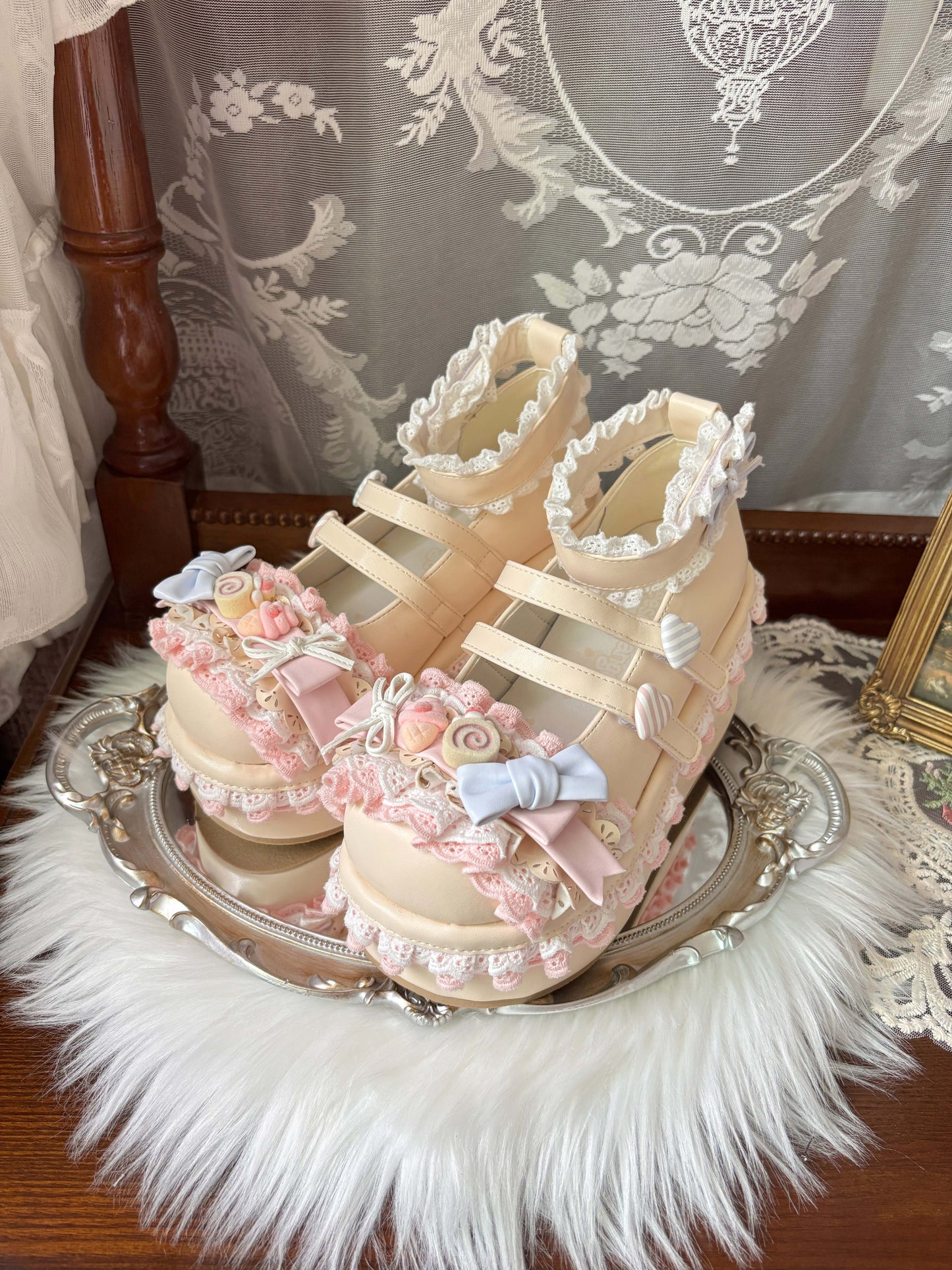 Pair of decorative yellow shoes with floral embellishments on a silver tray.