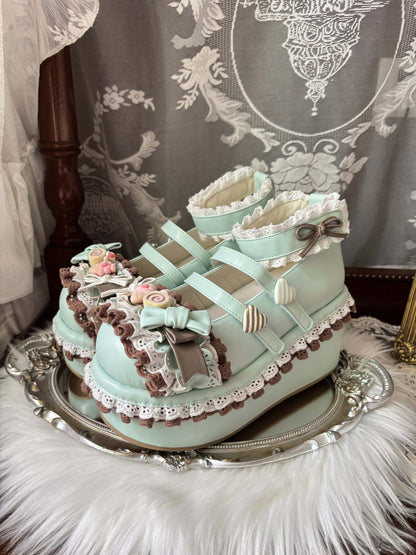 Decorative cake shaped like a baby shoe with intricate details on a silver platter.