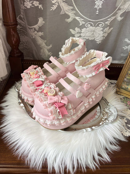 Pink decorative shoes with lace and bows on a white fur surface.