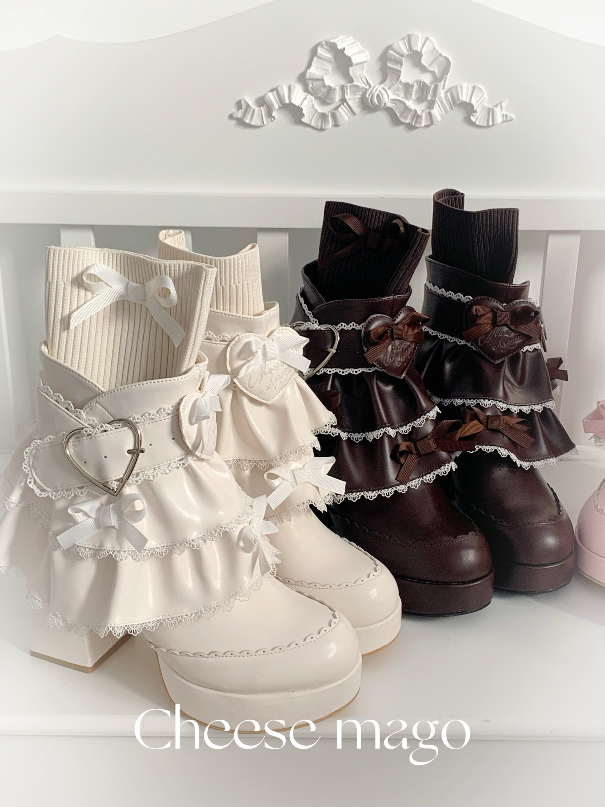 Pair of white and brown ruffled boots with decorative elements on a white background, featuring the brand 'Cheese mago'.