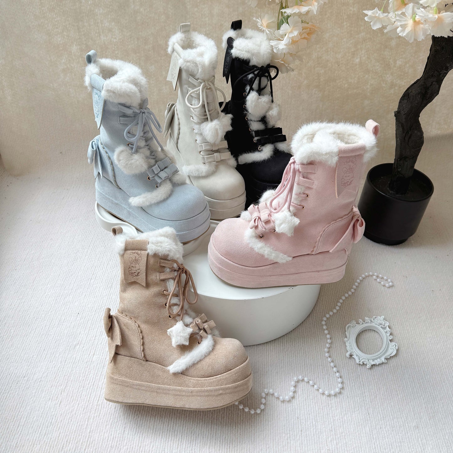 Set of pastel-colored boots with fluffy tops on a light surface.