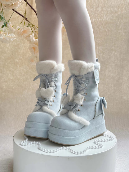 Light blue winter boots with white fur trim on a neutral background