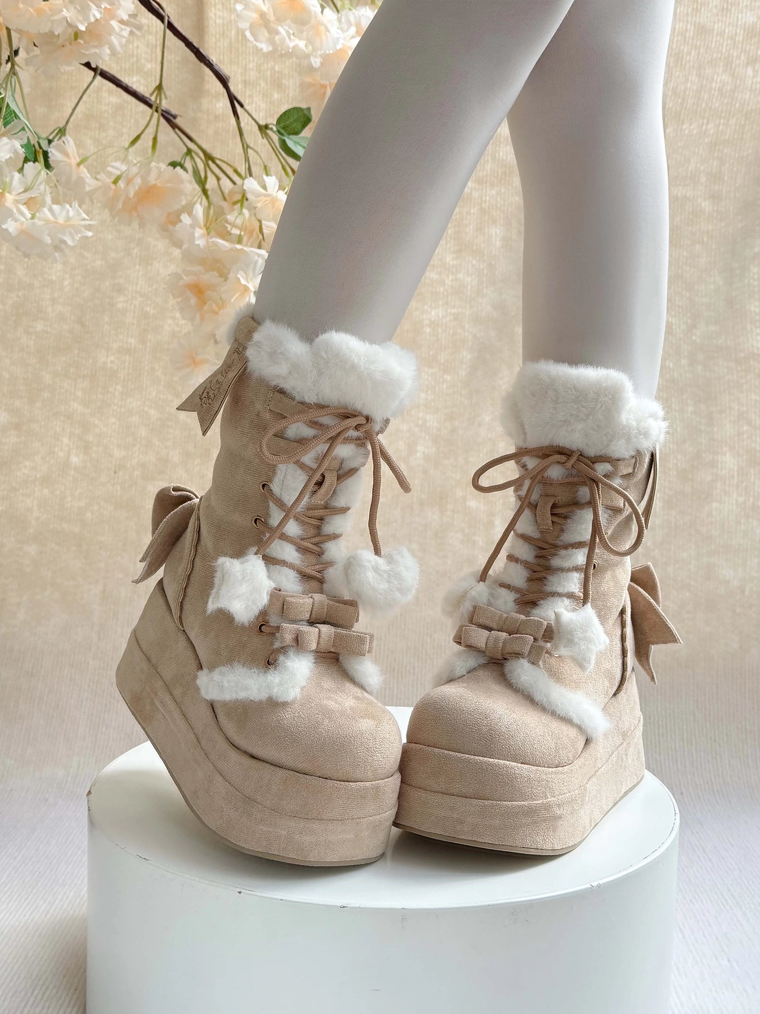 Beige platform winter boots with white fur trim on a neutral background