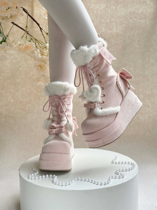 Pink boots with white fur and bows on a white pedestal against a light background