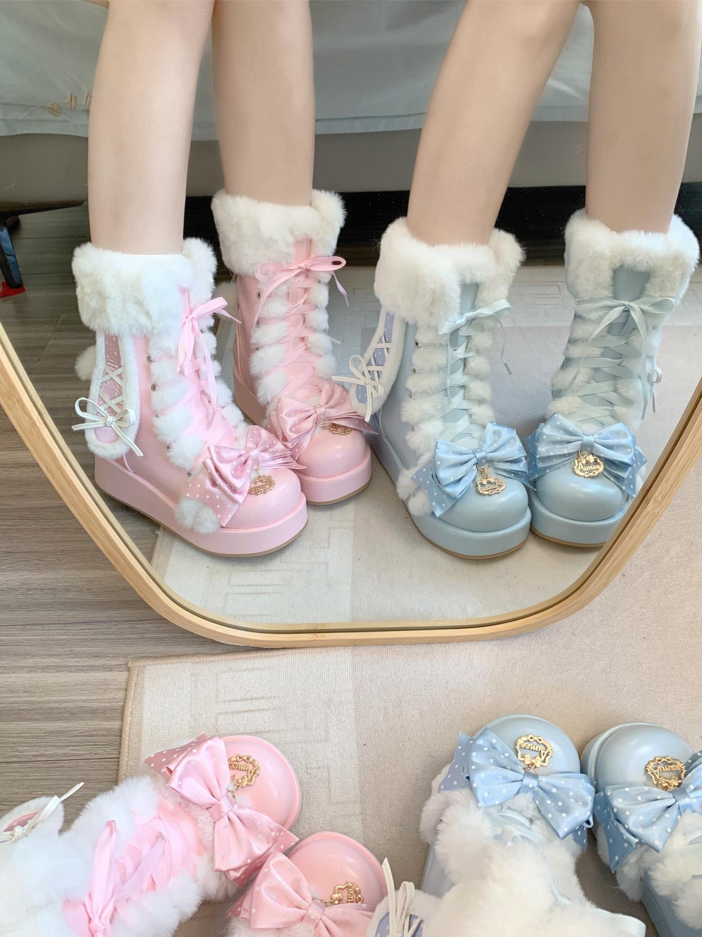 Pastel-colored children's boots with fluffy tops and decorative bows on a mirror surface.