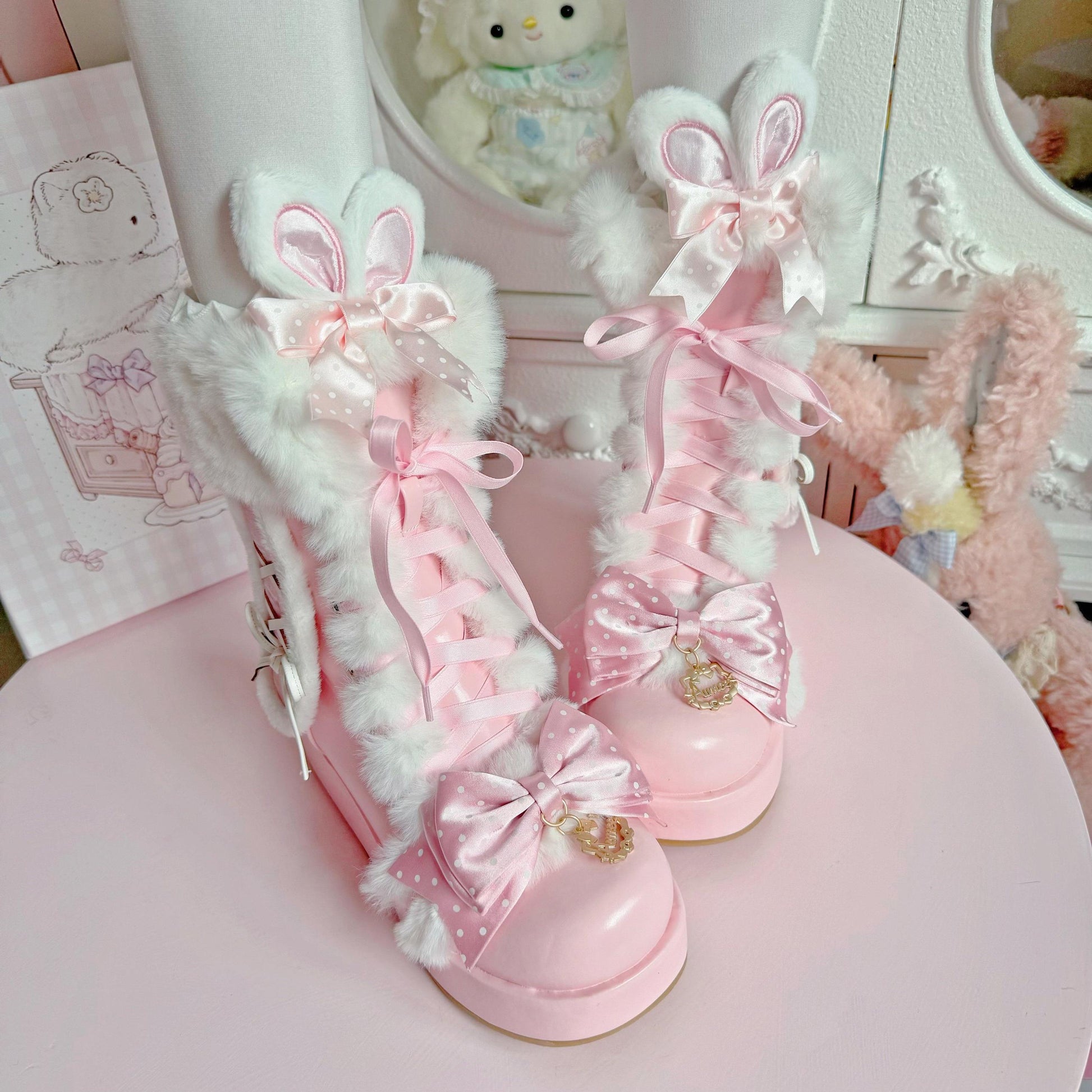 Pink and white bunny-themed shoes with decorative bows on a pink surface.