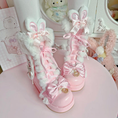 Pink and white bunny-themed shoes with decorative bows on a pink surface.