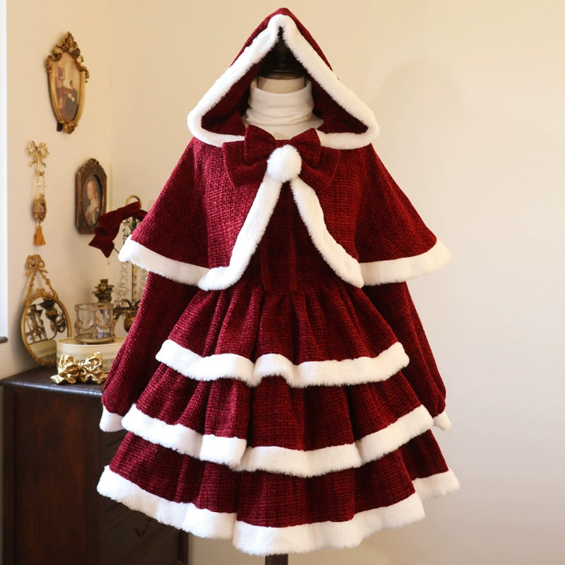 Red christmas dress and cape with white trim on a mannequin against a neutral wall.