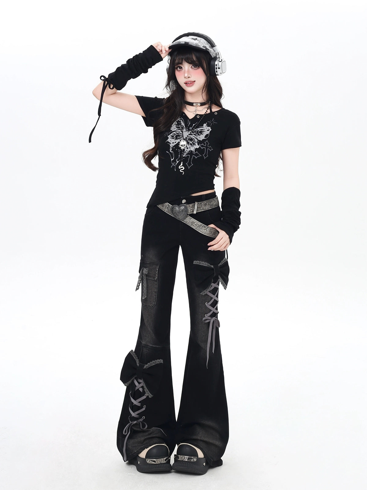 Person wearing a black outfit with lace-up details on a white background