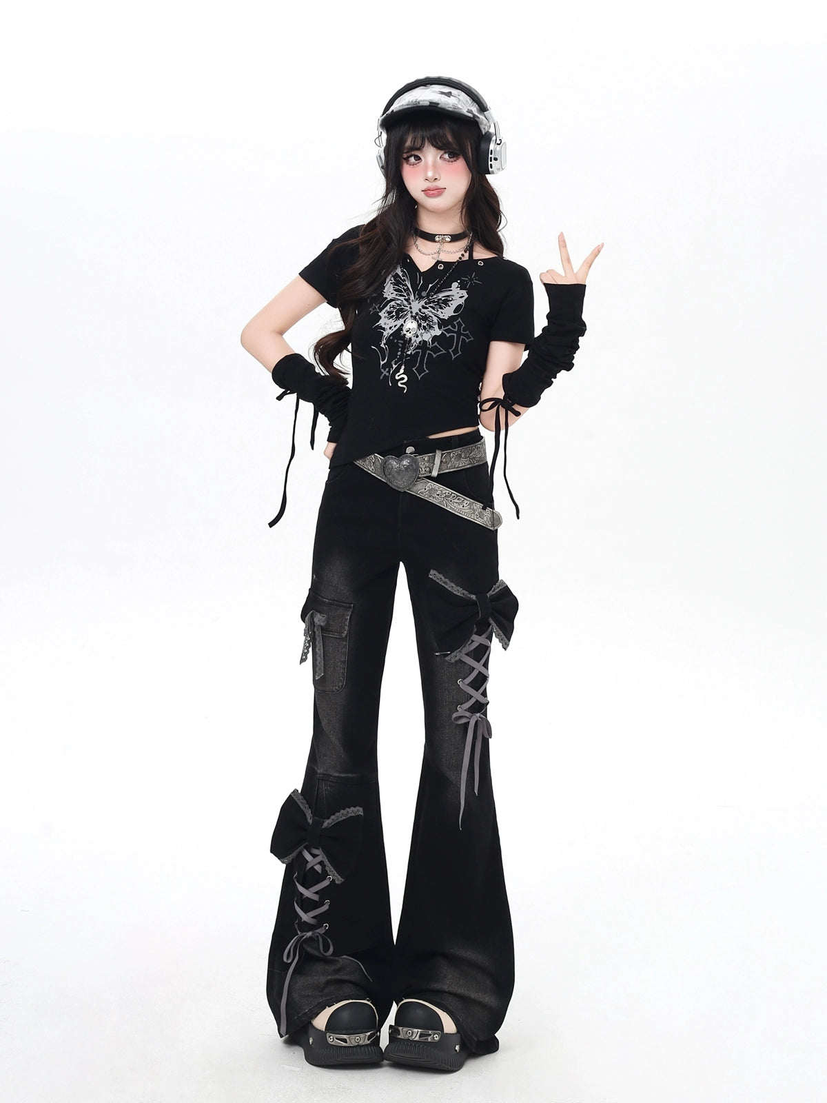 Person wearing a black outfit with lace-up details on a white background