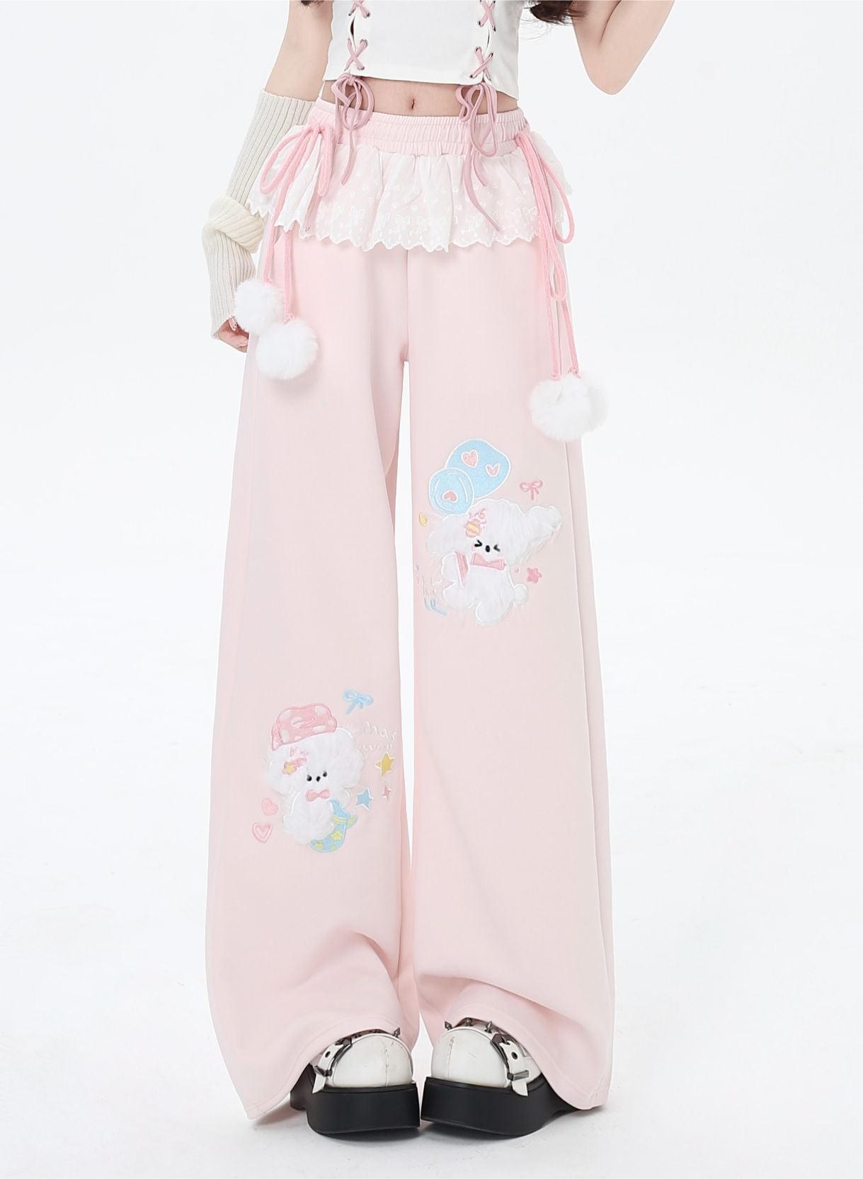 Pink pants with cartoon character design worn by a person on a white background