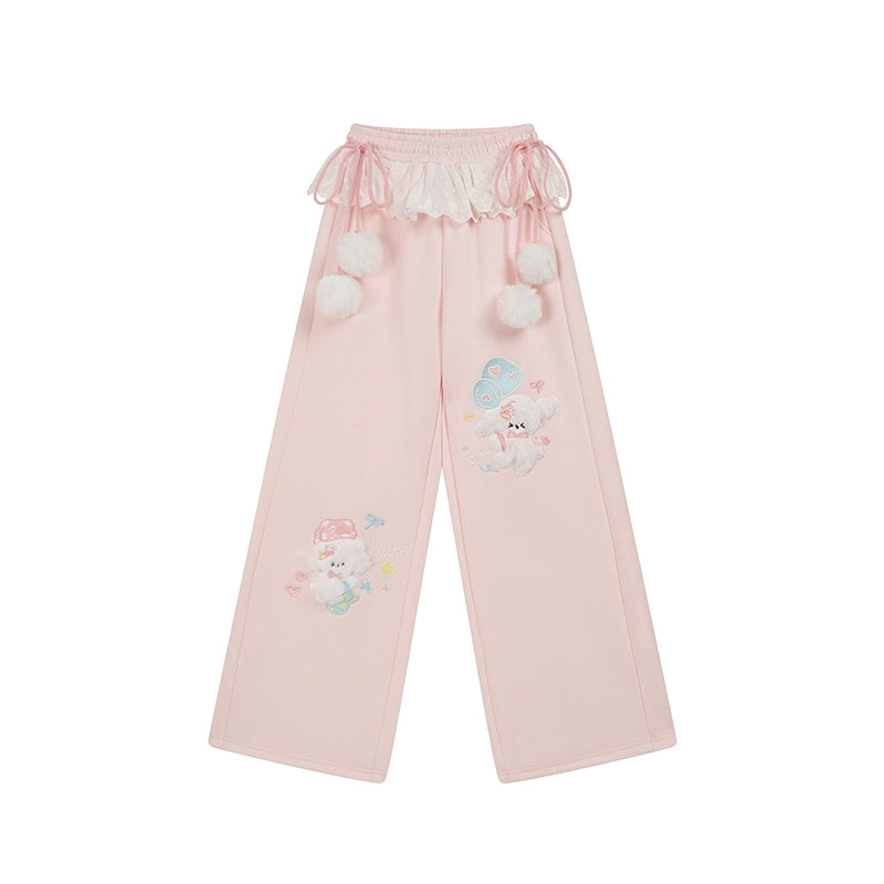 Pink pants with cartoon character and pom-pom details on a white background