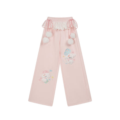 Pink pants with cartoon character and pom-pom details on a white background