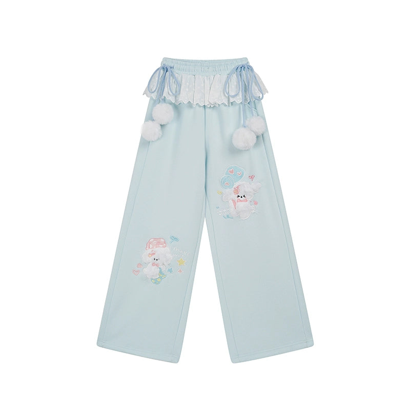 Light blue pants with cartoon character and pom-pom details on a white background