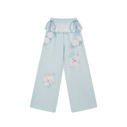 Light blue pants with cartoon character and pom-pom details on a white background