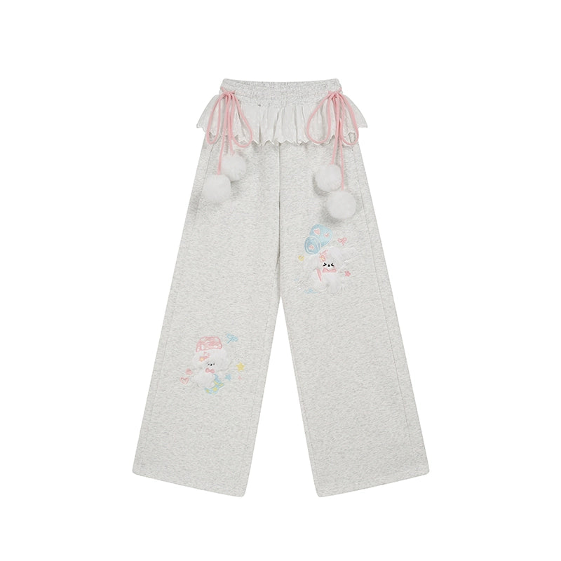 Gray pants with cartoon character and pom-pom details on a white background