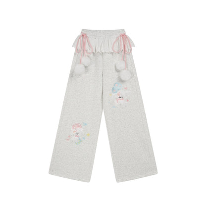 Gray pants with cartoon character and pom-pom details on a white background