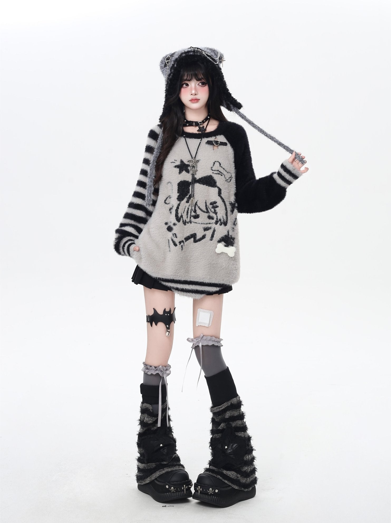 Person wearing a black and white outfit with cat ears and boots on a white background