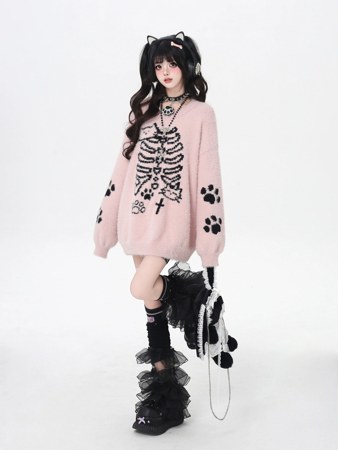Person wearing a pink sweater with black paw print design on a white background