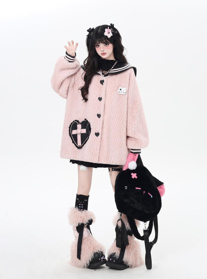 Person wearing a pink coat with black heart design, holding a black bag with pink accents.