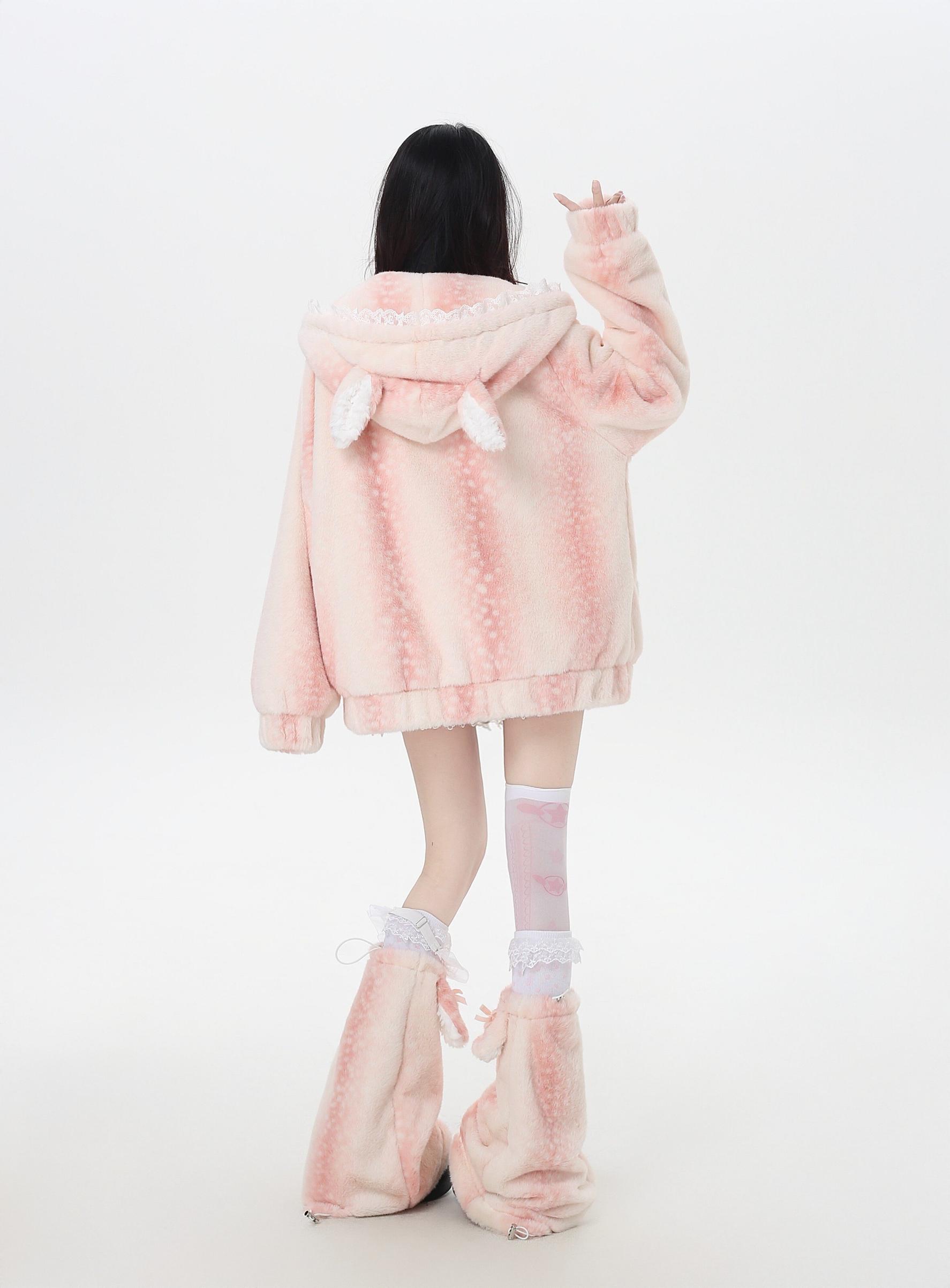 Person wearing a pink fluffy coat and matching shoes on a white background