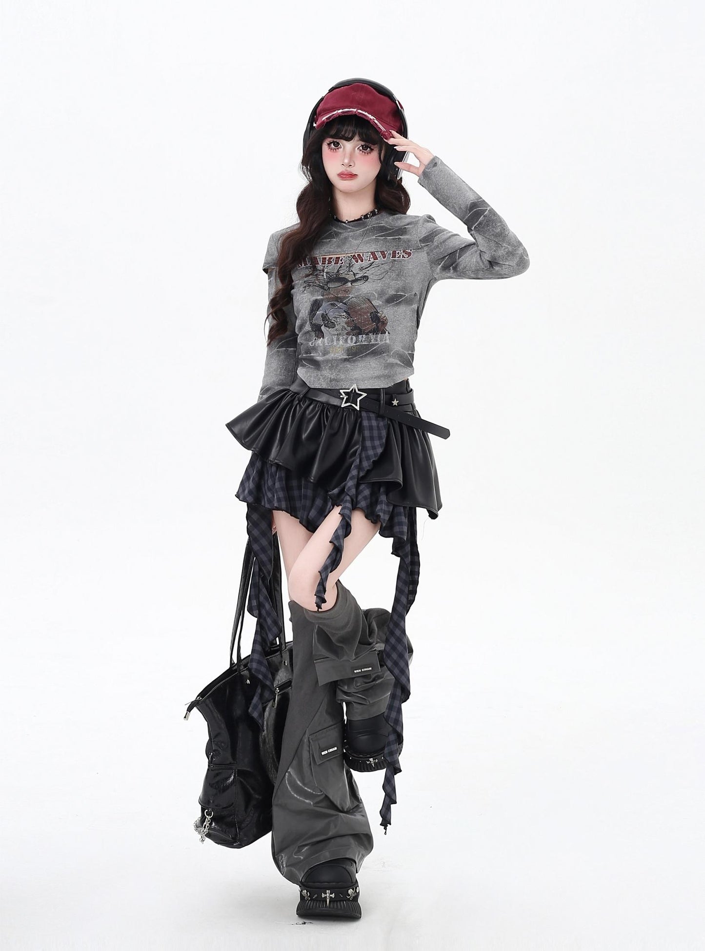 Person wearing a gray sweater and black skirt with a white background