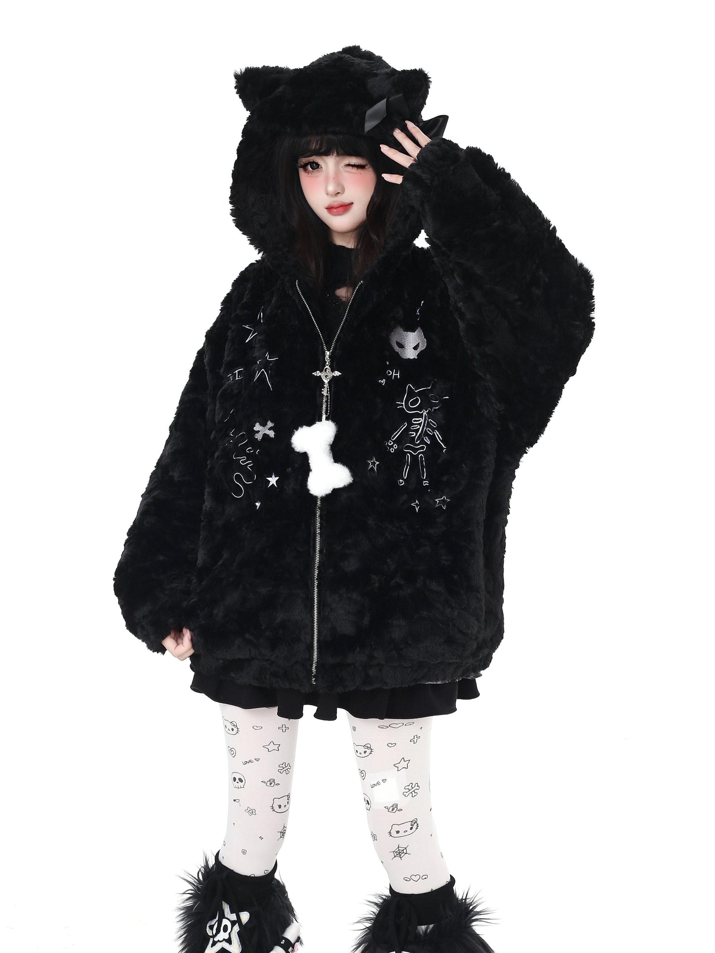 Person wearing a black fluffy hooded coat with cat ears on a white background