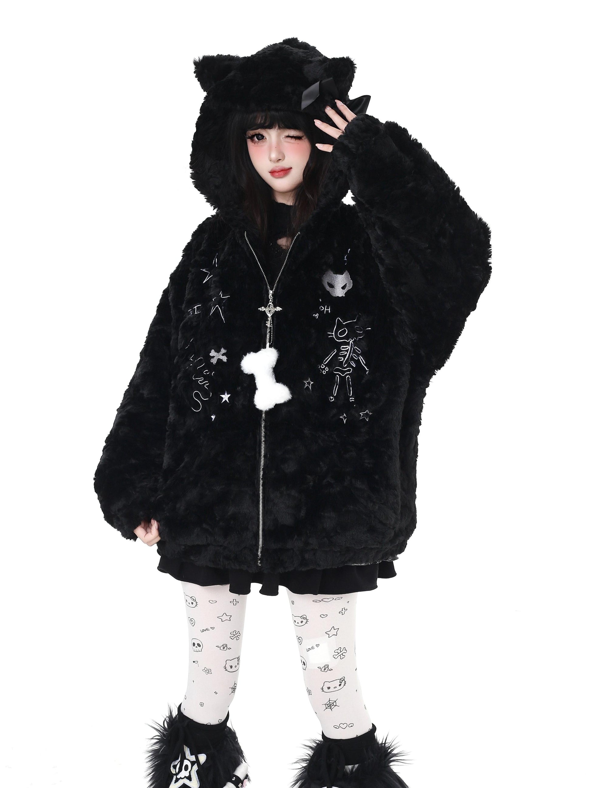 Person wearing a black fluffy hooded coat with cat ears on a white background