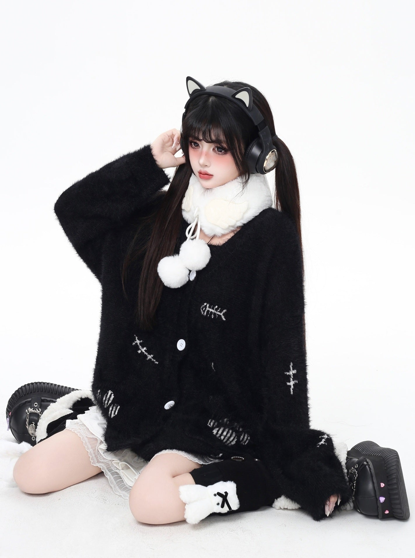 Person wearing a black outfit with white accents and cat ears on a white background