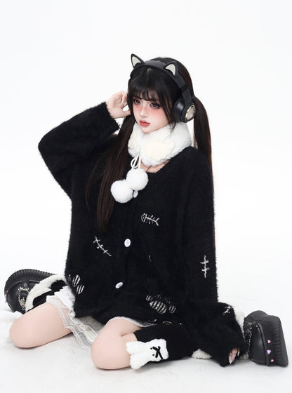 Person wearing a black outfit with white accents and cat ears on a white background