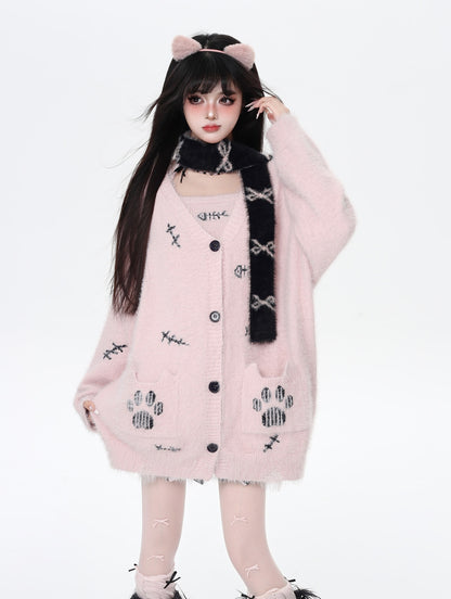 Person wearing a pink cardigan with paw print patterns on a white background