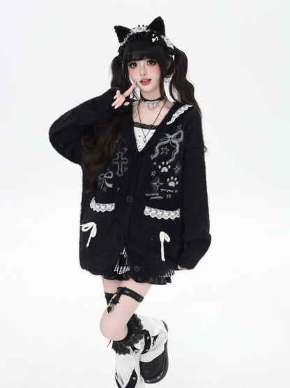 Person wearing a black cardigan with cat ears and paws on a white background
