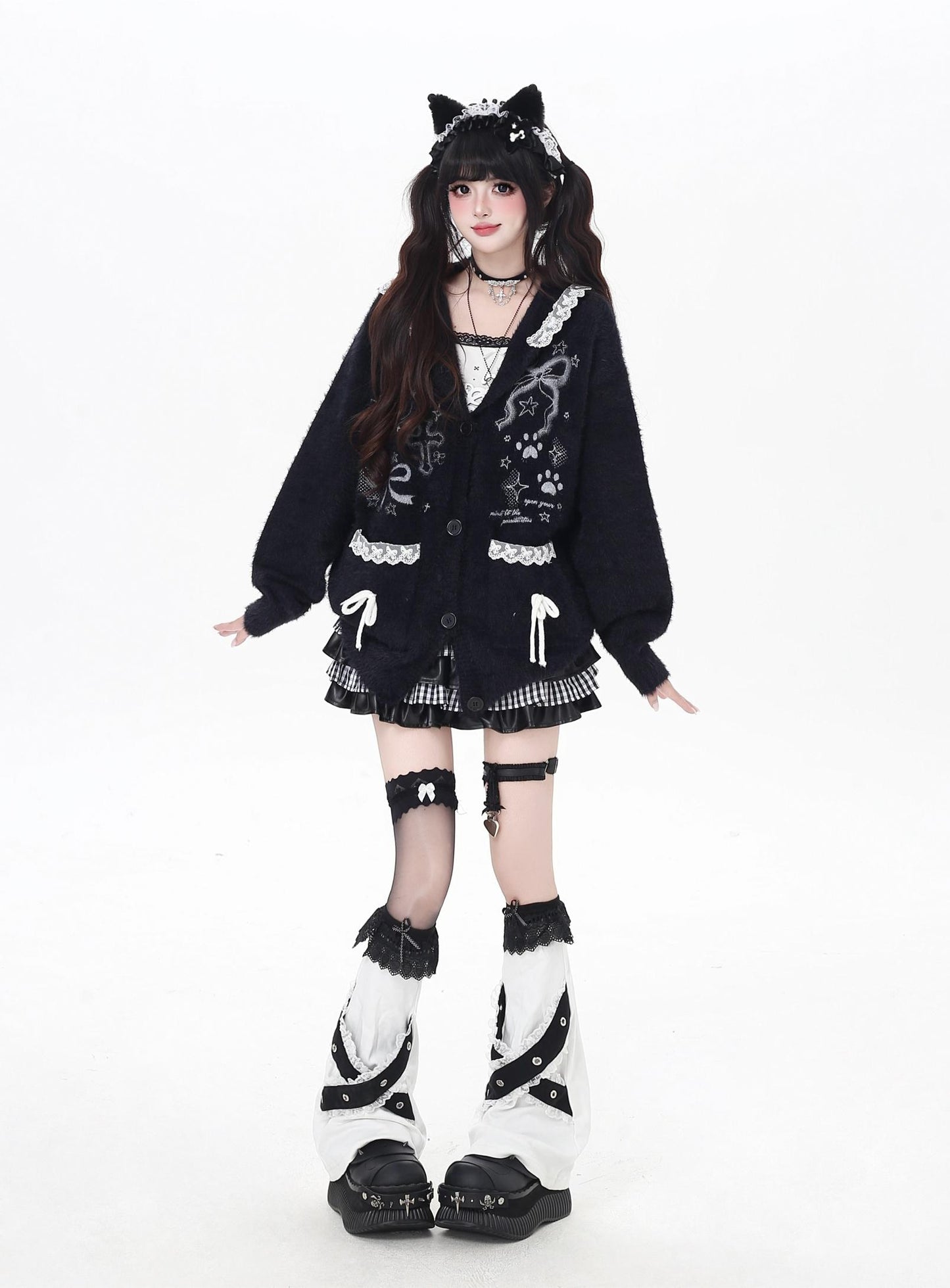 Person wearing a black and white outfit with cat ears on a white background