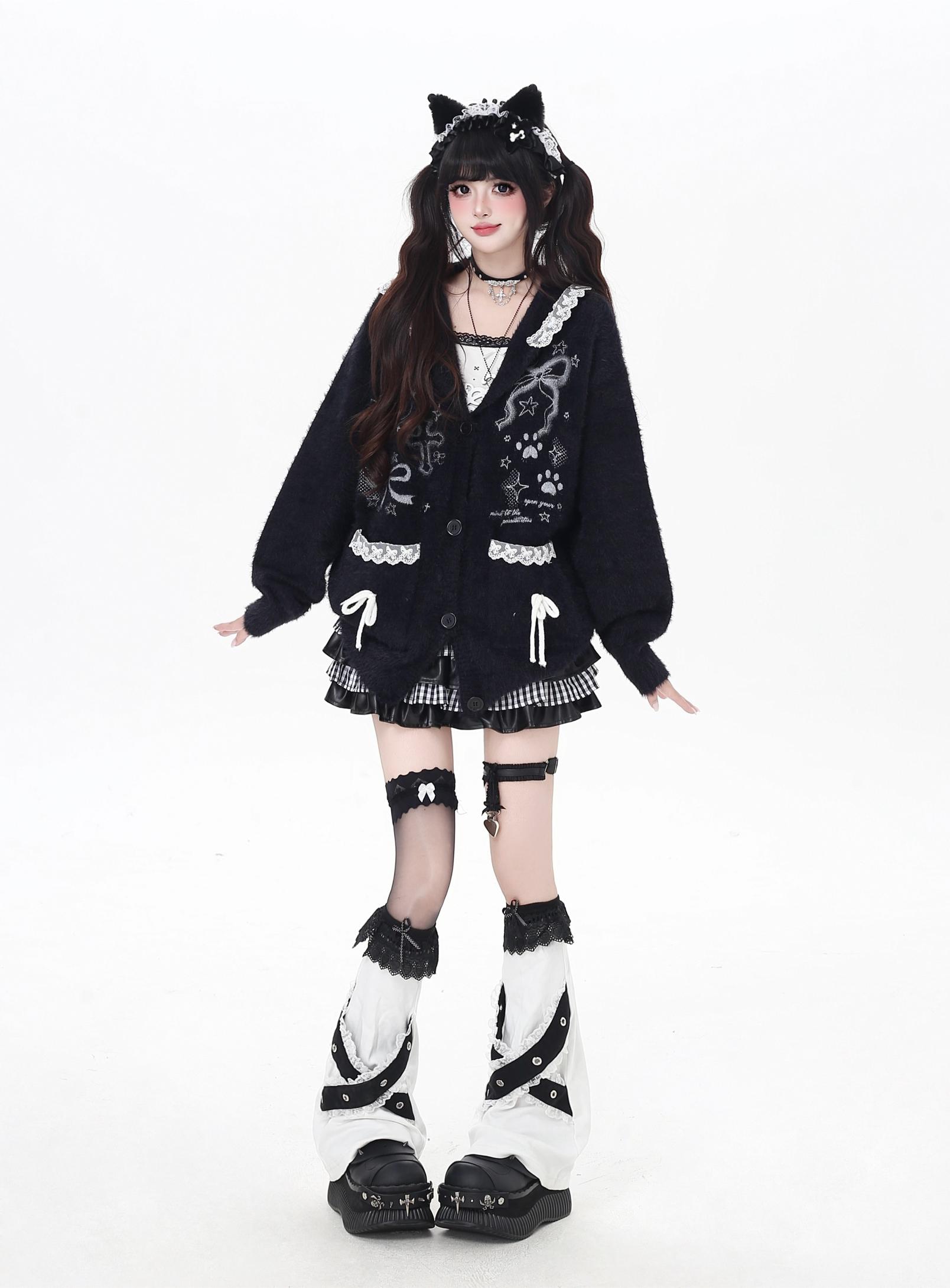 Person wearing a black and white outfit with cat ears on a white background